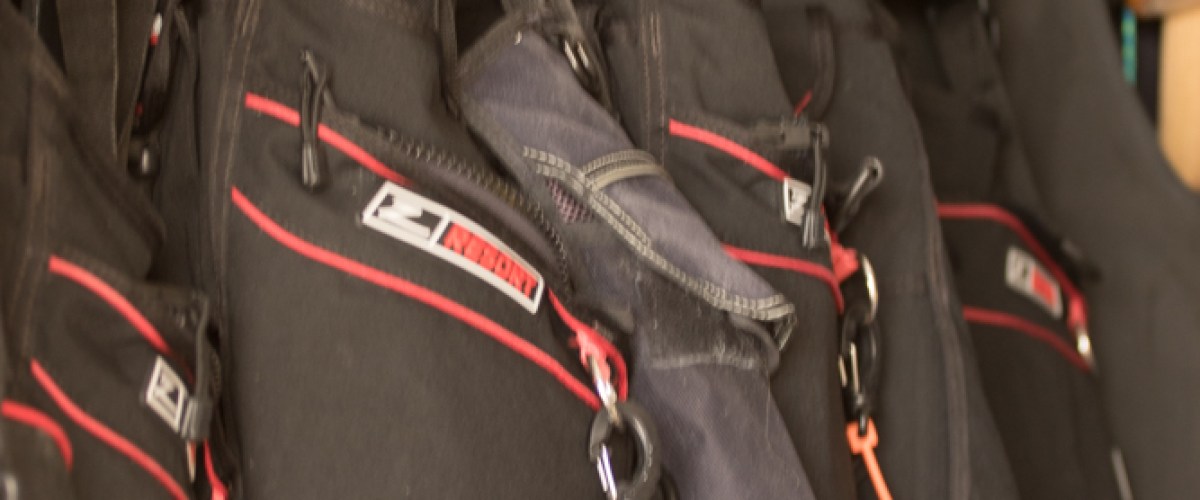 Scuba vests in a row on hangers