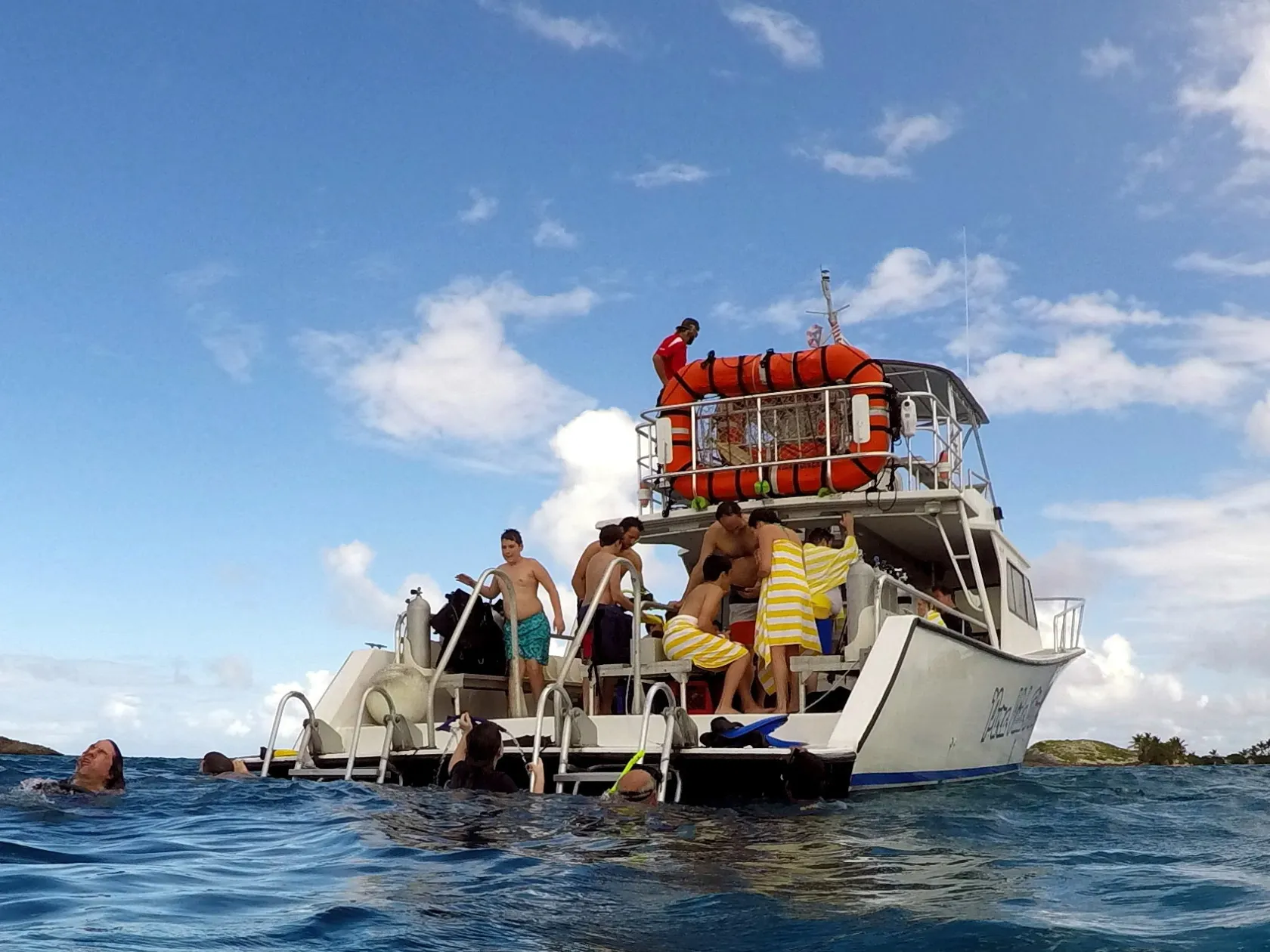 swimmers jumping off boat